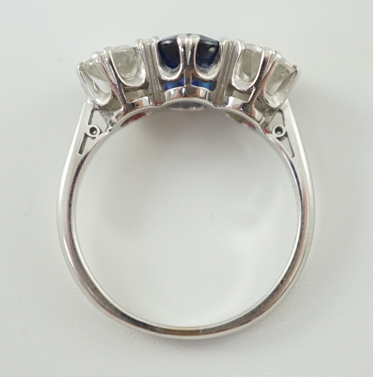 A modern 18ct white gold, single stone oval cut sapphire and two stone round cut diamond set ring